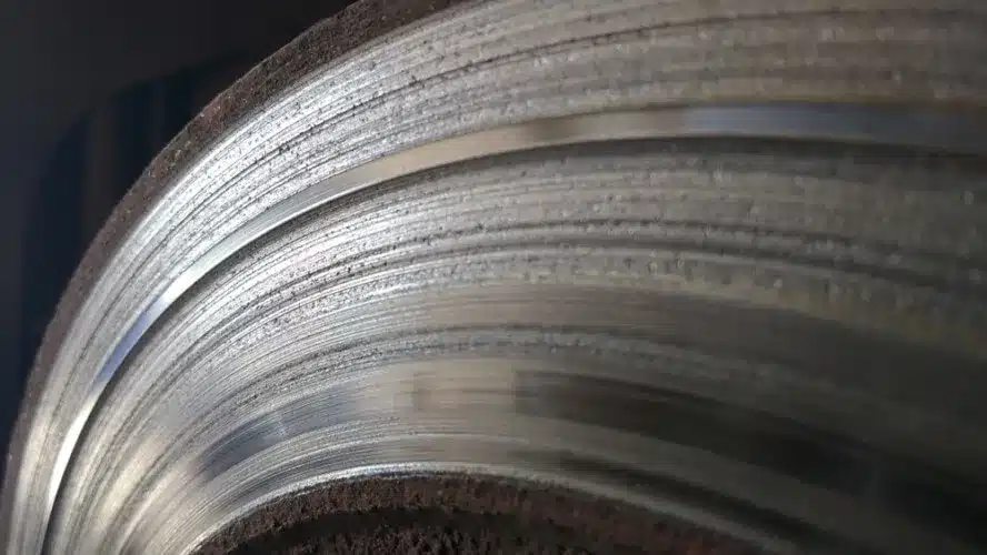 Disco de freno desgastado con evidentes marcas de contacto con el metal de las pastillas.