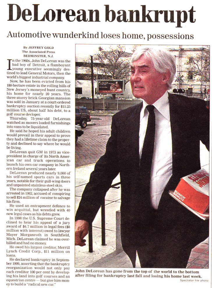 Artículo de periódico con la fotografía de John DeLorean, con cara de estrés. Lleva bajo el brazo documentos legales o archivos y una caja de Dunkin Donuts, lo que podría sugerir una situación de estrés o preocupación. El titular en español “Prodigio automotriz pierde hogar y posesiones” acompaña la imagen, señalando un período de adversidad financiera para el destacado individuo de la industria automotriz.