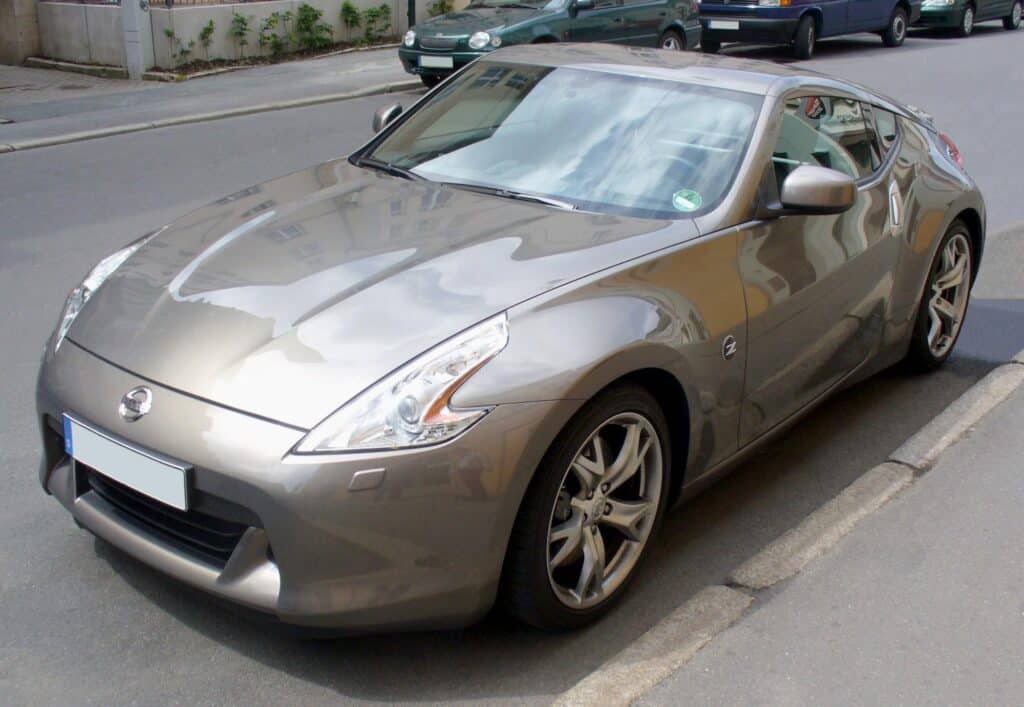 Imagen de un Nissan 370Z plateado estacionado en una calle urbana. Diseño distintivo y moderno.