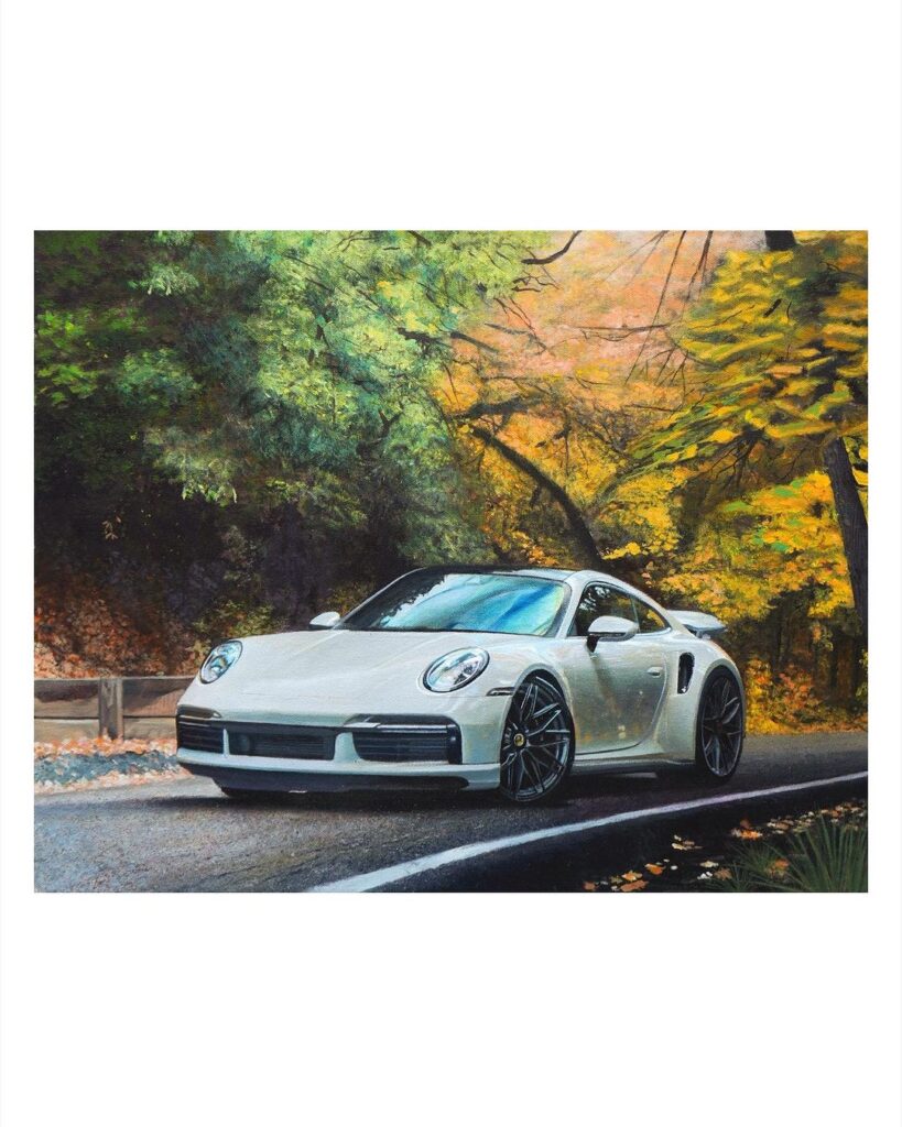 La imagen muestra una pintura de un coche Porsche plateado estacionado al lado de una carretera rodeada de vegetación exuberante y árboles con hojas de colores otoñales. La escena parece ser durante el día, con la luz del sol filtrándose a través del follaje, destacando el diseño elegante del vehículo y creando un contraste interesante entre la tecnología y la naturaleza. Esta obra es de la artista Rae Roberts.