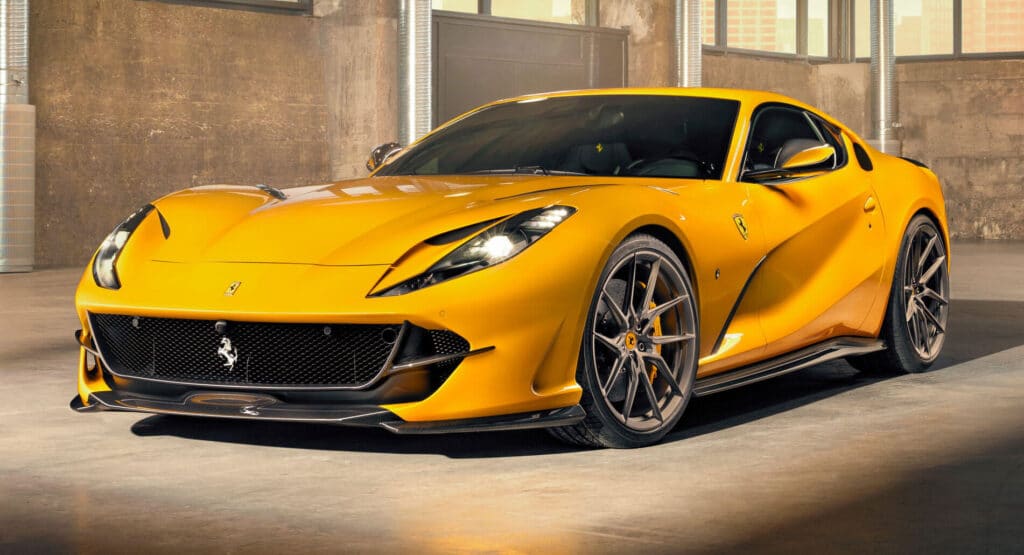 Ferrari 812 Superfast amarillo estacionado en un entorno interior con iluminación cálida y ambiental. El coche está posicionado en un ángulo que muestra su diseño aerodinámico, incluyendo el icónico logo del caballo encabritado en la parrilla frontal, líneas aerodinámicas y grandes tomas de aire en el capó y los laterales, características de los coches deportivos de alto rendimiento. Los elementos de diseño del vehículo sugieren velocidad y lujo.