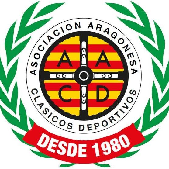 Logotipo de la ‘Asociación Aragonesa de Clásicos Deportivos’, con un diseño circular de corona de laurel verde alrededor de la parte central, que está oscurecida por un rectángulo borroso. En la parte inferior de la corona, hay una banda roja con el texto ‘DESDE 1980’ en letras blancas, indicando el año de establecimiento.