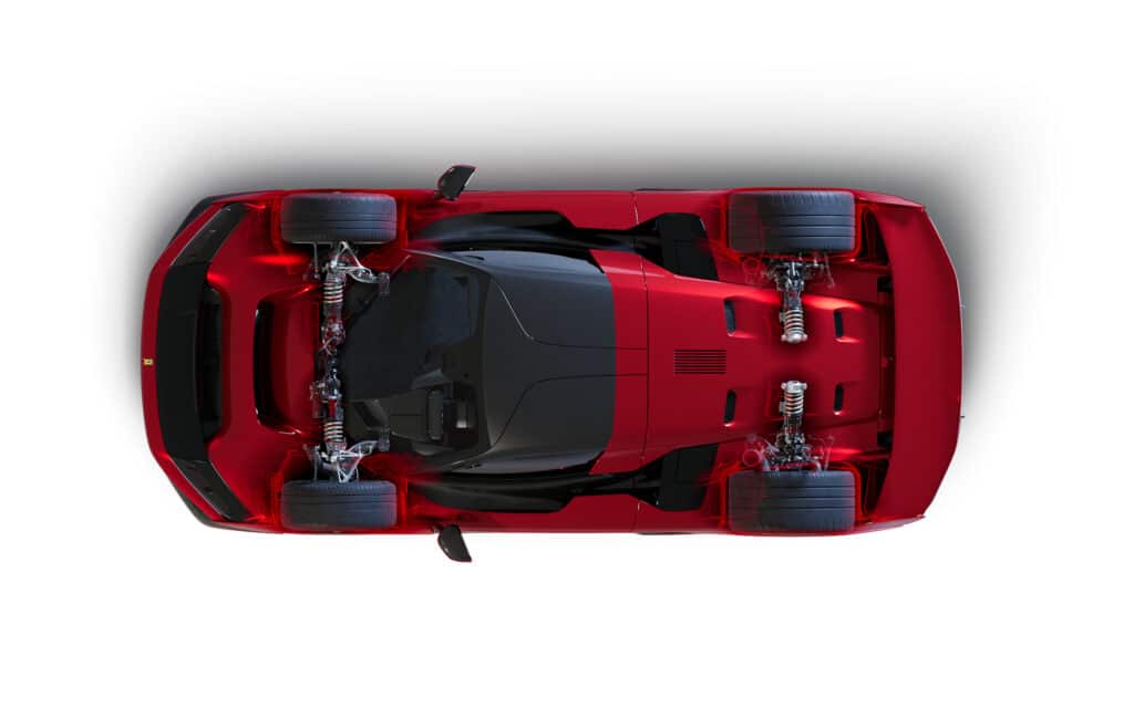 Vista superior de un Ferrari F80 rojo. El coche está aislado sobre un fondo blanco, destacando su diseño aerodinámico, la forma elegante de la carrocería, las ruedas y el sistema de suspensión visible.