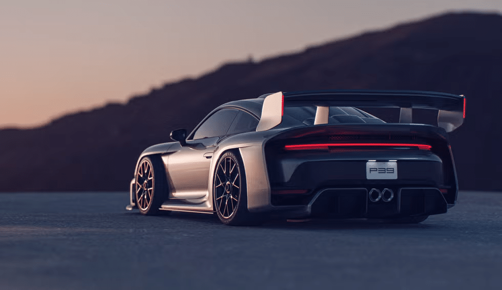 Vista trasera de un Porsche 911 RML P39 plateado durante el atardecer, con un alerón trasero prominente y líneas de carrocería elegantes. El coche está en una carretera abierta con un fondo borroso que sugiere un área vasta y abierta. La iluminación resalta las características de diseño del coche, dando una estética dramática y de alta calidad.
