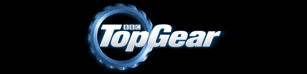 Logo de Top Gear con un engranaje metálico y reflectante detrás del texto en mayúsculas ‘Top Gear’ sobre un fondo negro.