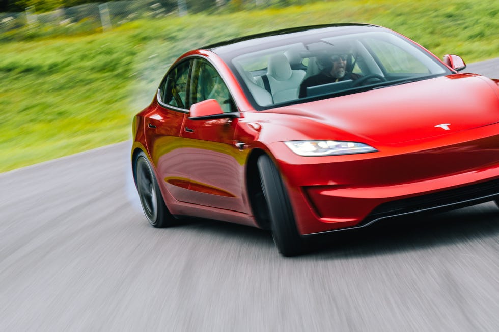 Claro, aquí tienes: La imagen muestra un coche Tesla rojo conduciendo en una carretera. El coche está en movimiento y el fondo está borroso, lo que indica velocidad. El coche está girando y se puede ver a una persona dentro, conduciendo el vehículo. El logotipo de Tesla se muestra de manera prominente en la parte frontal del coche. La imagen es interesante y relevante ya que muestra un vehículo eléctrico moderno en acción, destacando su diseño y capacidades de rendimiento.
