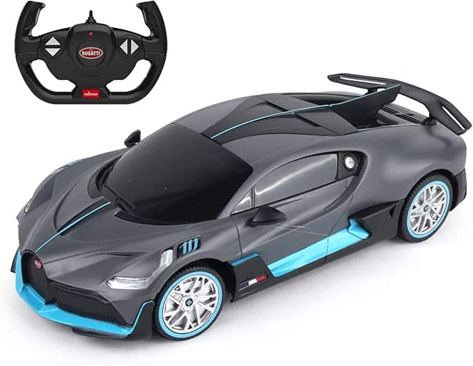 La imagen muestra un coche de juguete teledirigido modelado como un Bugatti deportivo. El coche es predominantemente gris con acentos azules y presenta elementos de diseño detallados como un alerón trasero, líneas aerodinámicas y ruedas realistas. El control remoto, que también es visible en la imagen, es negro y tiene forma de volante con botones para controlar el coche. El logotipo de Bugatti está prominentemente exhibido en el control remoto. Esta imagen es interesante porque muestra una réplica de alta calidad y detallada de un coche deportivo de lujo, que puede ser atractivo tanto para los entusiastas de los coches como para los niños interesados en vehículos teledirigidos.
