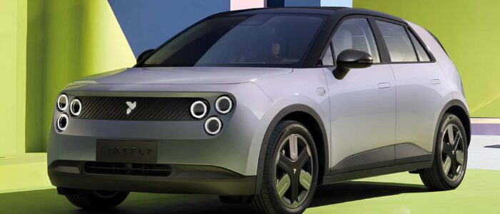 Un coche eléctrico compacto NIO Firefly con un diseño moderno y elegante. El coche tiene un frontal distintivo con cuatro faros circulares y una parrilla minimalista. La matrícula muestra el nombre 'FIREFLY'. El coche está ambientado en un fondo colorido y abstracto con tonos de verde, azul y rosa, lo que añade un toque vibrante y futurista a la imagen. Esta imagen es interesante y relevante ya que muestra un vehículo eléctrico contemporáneo, destacando los avances en diseño y tecnología automotriz.