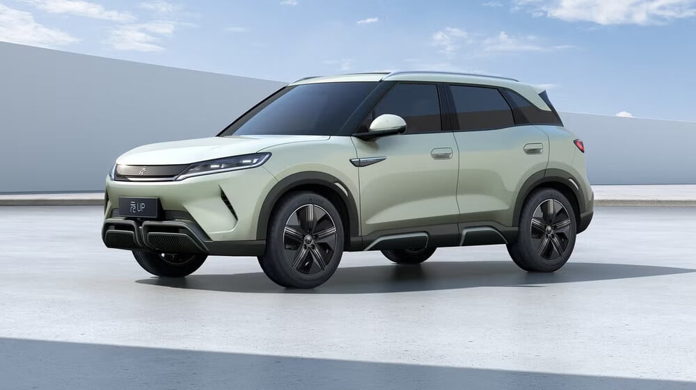 Imagen de un BYD Atto 2, un SUV compacto con un diseño elegante y moderno. El vehículo está estacionado sobre una superficie lisa y clara, con un cielo azul despejado de fondo. El coche presenta un exterior de color verde claro, con detalles en negro y llantas de aleación estilizadas. La parte frontal del coche tiene una parrilla distintiva y faros LED afilados, mientras que el perfil lateral muestra líneas suaves y una postura ligeramente elevada, típica de un SUV. Esta imagen es interesante y relevante ya que destaca el diseño y el atractivo estético del BYD Atto 2, lo que puede atraer a posibles compradores o entusiastas del automóvil.