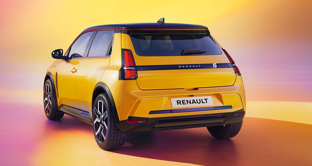 La imagen muestra la vista trasera de un Renault 5 E-Tech amarillo con un diseño moderno y elegante. El coche tiene luces traseras distintivas, un techo negro y un logotipo prominente de Renault en la parte trasera. El fondo tiene un degradado de colores cálidos, incluyendo amarillo, naranja y rosa, lo que añade a la apariencia vibrante y llamativa del coche. Esta imagen es interesante y relevante ya que destaca el diseño y la marca de un vehículo Renault, mostrando un modelo nuevo o próximo.