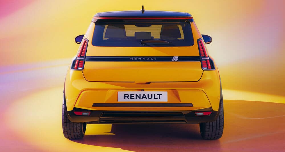 La imagen muestra la vista trasera de un Renault 5 E-Tech amarillo con un diseño moderno y elegante. El coche tiene luces traseras distintivas, un techo negro y un logotipo prominente de Renault en la parte trasera. El fondo tiene un degradado de colores cálidos, incluyendo amarillo, naranja y rosa, lo que añade a la apariencia vibrante y llamativa del coche. Esta imagen es interesante y relevante ya que destaca el diseño y la marca de un vehículo Renault, mostrando un modelo nuevo o próximo.