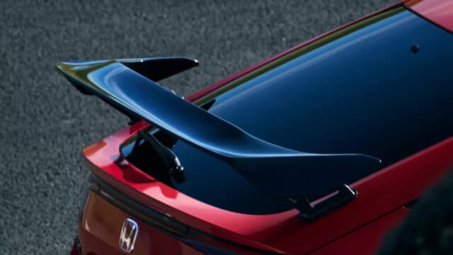 Detalle del alerón trasero deportivo del Civic Type R 2025, mostrando su diseño aerodinámico en negro brillante contrastando con la carrocería roja.