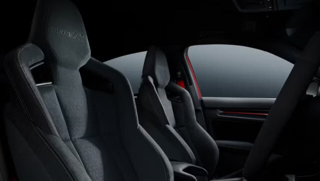 Vista lateral de los asientos deportivos delanteros del Civic Type R 2025, mostrando el diseño ergonómico con soporte lateral y tapicería negra con costuras rojas.
