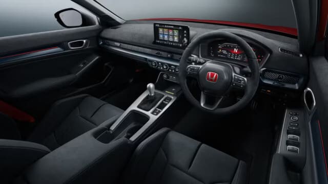 Interior del Honda Civic Type R 2025 mostrando el tablero deportivo con pantalla digital, volante deportivo con logo Honda rojo, palanca de cambios manual y asientos deportivos en negro.