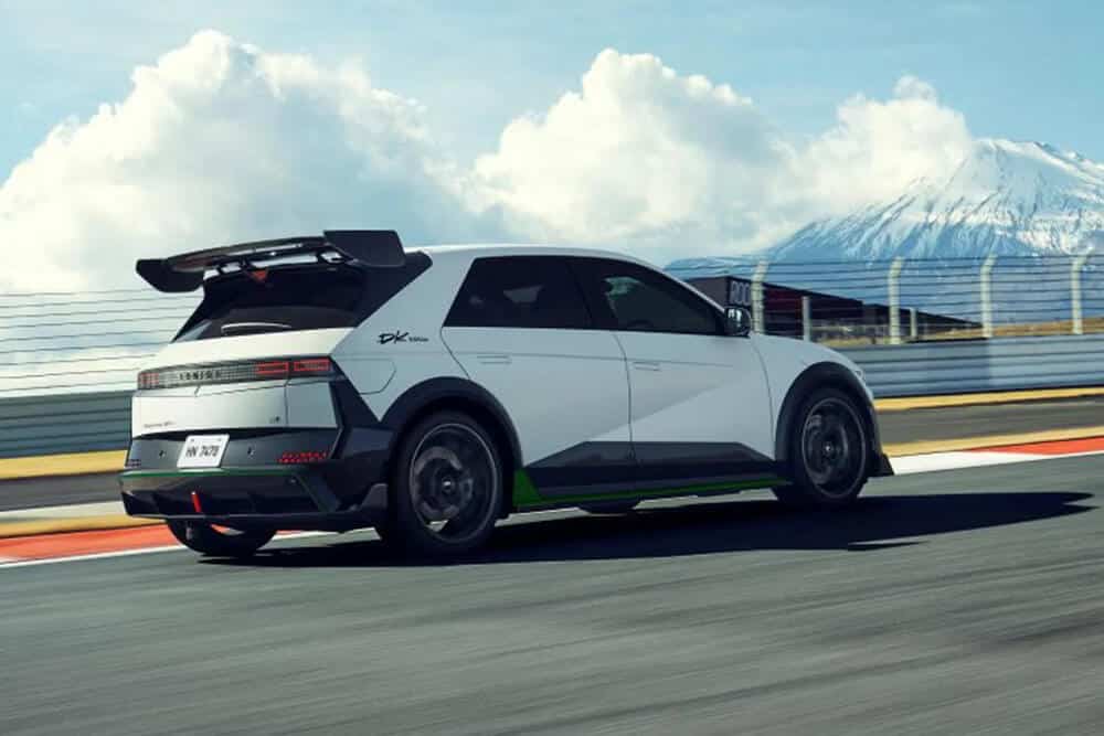Vista trasera del Hyundai Ioniq 5 N DK Edition en un circuito, con el Monte Fuji al fondo. Destaca su alerón trasero y diseño aerodinámico.