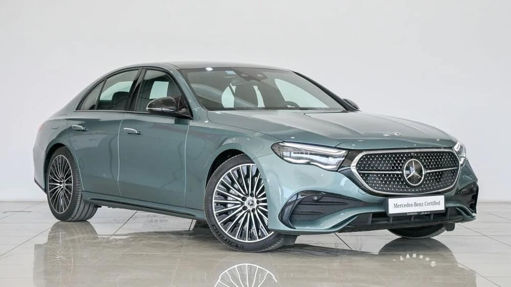 "Un Mercedes-Benz Clase E modelo 2024, expuesto en un showroom de Dubái. El coche destaca por su diseño elegante y moderno, con una parrilla frontal distintiva y llantas de aleación llamativas. Esta imagen es relevante para el tema 'importar coches de Dubái a España', mostrando un vehículo de alta gama ideal para compradores interesados en la importación.