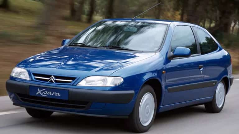 En la imagen se presenta un Citroën Xsara 1.6i Exclusive de 1999, un hatchback azul de cinco puertas, estacionado junto a un paisaje urbano con árboles que adornan el fondo. Este vehículo, emblema de la década de los 90, refleja una época en la que la ingeniería automovilística priorizaba la durabilidad, el diseño elegante y el confort. Los coches de los años 90, como este Citroën Xsara, se caracterizaban por su fiabilidad mecánica, la calidad de sus materiales y un enfoque único en la experiencia del conductor y los pasajeros. Aunque los avances tecnológicos han cambiado la industria, muchos entusiastas creen que los automóviles modernos todavía no han alcanzado el equilibrio perfecto entre estética, funcionalidad y resistencia que ofrecían los modelos de los años 90. Este Citroën, con su diseño aerodinámico y detalles exclusivos, es un testimonio de aquella excelencia automovilística.