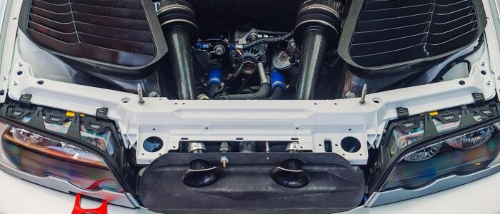 BMW M3 GTR Most Wanted (8) La imagen muestra el compartimento del motor de un BMW M3 GTR con el capó abierto. La cubierta del motor muestra prominentemente el texto "BMW Power". El compartimento del motor está limpio y bien organizado, con componentes visibles como los sistemas de admisión de aire a ambos lados, varias mangueras y elementos estructurales. Este coche es famoso por su aparición en el videojuego "Need for Speed: Most Wanted", donde juega un papel central. La imagen es interesante y relevante para los entusiastas del automovilismo y los fans del juego.