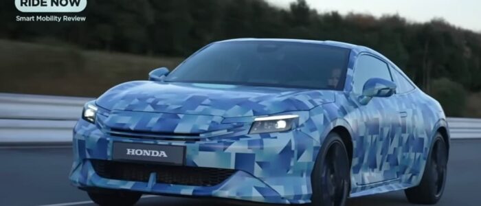 "Un Honda Prelude 2026 en un entorno urbano, con un diseño elegante y moderno. El coche tiene líneas aerodinámicas y un acabado en color blanco brillante. Las ventanas están tintadas en negro y las llantas de aleación son de color negro, lo que le da un aspecto deportivo y sofisticado. El fondo muestra edificios y una calle bien iluminada, destacando el coche como el centro de atención.