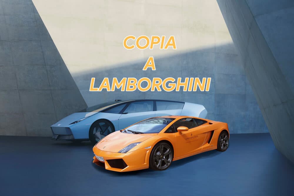 Imagen de dos automóviles estacionados uno al lado del otro en un entorno moderno de concreto. A la izquierda, un Honda 0 Saloon de color azul claro con un diseño futurista. A la derecha, un Lamborghini Gallardo de color naranja. En el centro de la imagen, se muestra el texto 'COPIA A LAMBORGHINI' en letras amarillas y negritas, sugiriendo una comparación o imitación entre los dos vehículos.